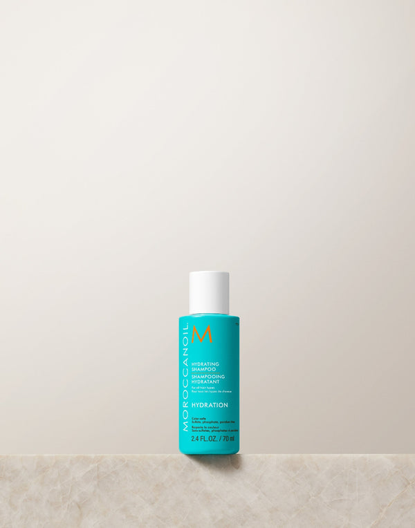 Moroccanoil bottle 2.4 oz travel size on a light beige background