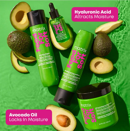Four green Matrix hair care products arranged on a bright green textured background with sliced avocados around them. Text callouts read 'Hyaluronic Acid Attracts Moisture' and 'Avocado Oil Locks in Moisture.