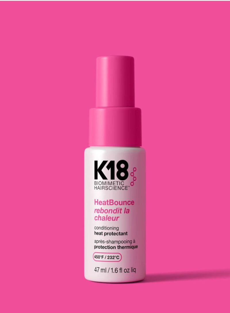 K18 HeatBounce conditioning heat protectant bottle of 1.6 oz on a pink background