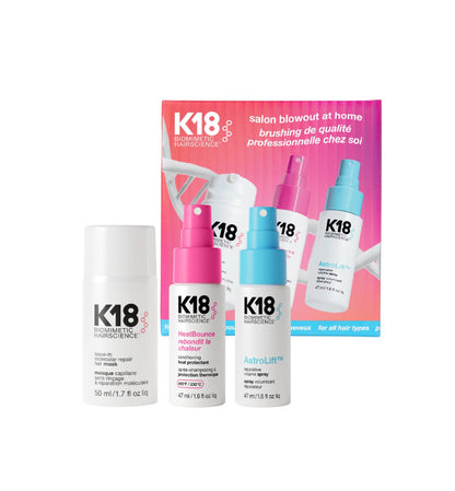 K18 Biomett Hairscience salon blowout at home kit containing three bottles (Hairpower Repair, Heat Bomb, AstroLift) in front of a pink and blue product box on a white background.