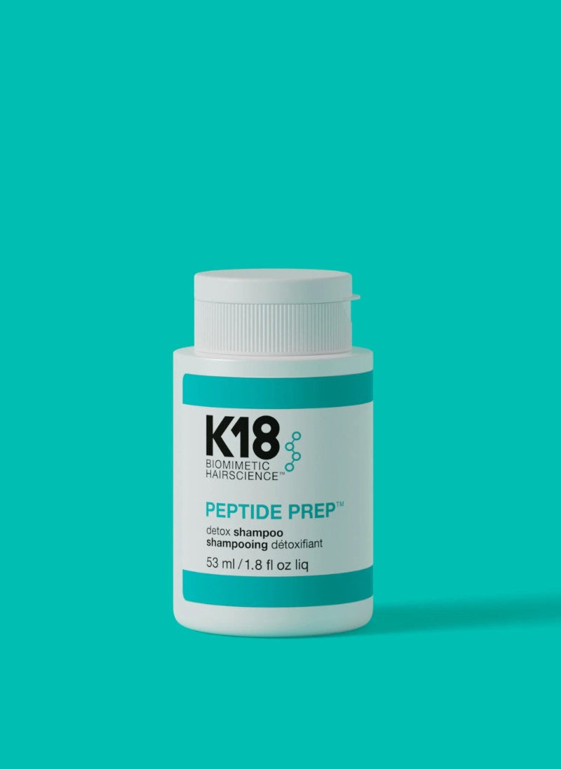 K18 Peptide Prep detox mini size shampoo bottle on a teal background