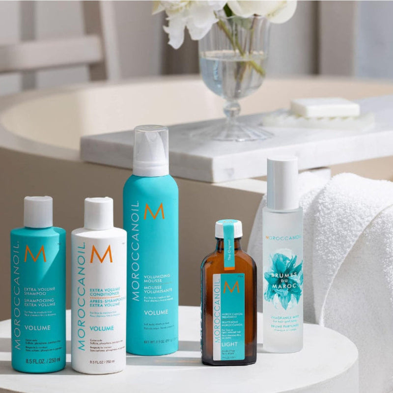 Collection of Moroccanoil hair care products on a table with a blurred background