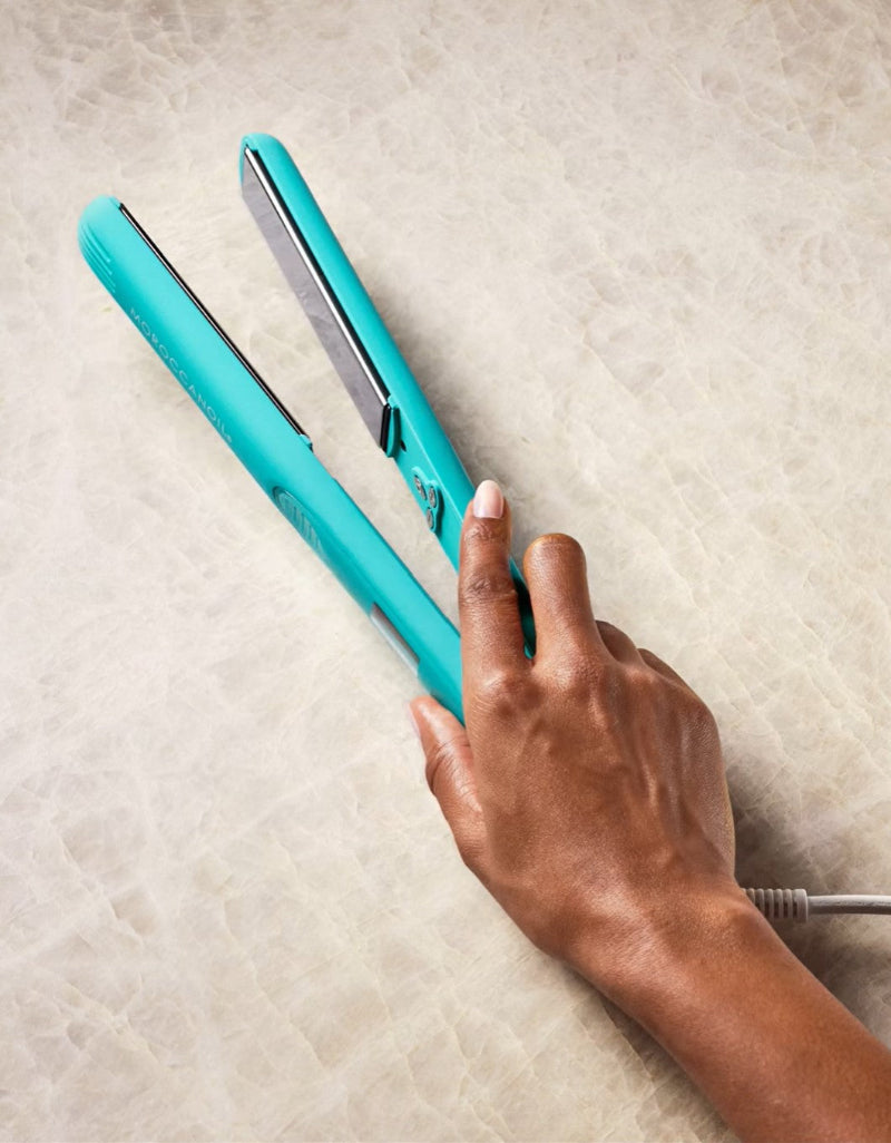 Moroccanoil perfectly finish flat iron holding by a person 