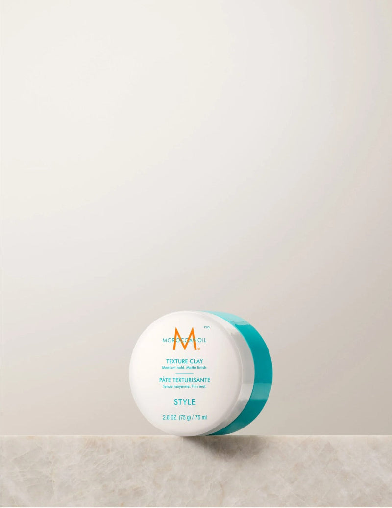 Jar of Moroccanoil texture clay hair product with a visible brand logo on a neutral background