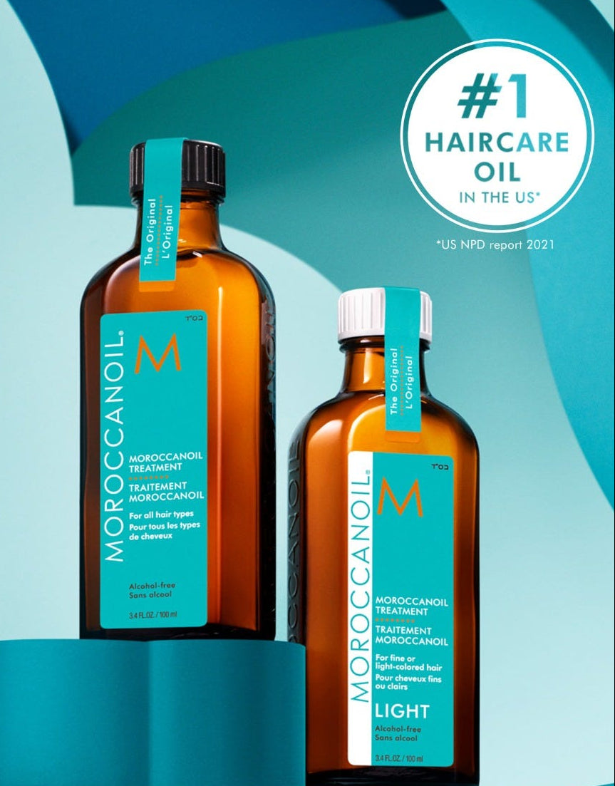 Two bottles of Moroccanoil hair care products on a blue and green gradient background with a '#1 Haircare Oil in the US' badge.