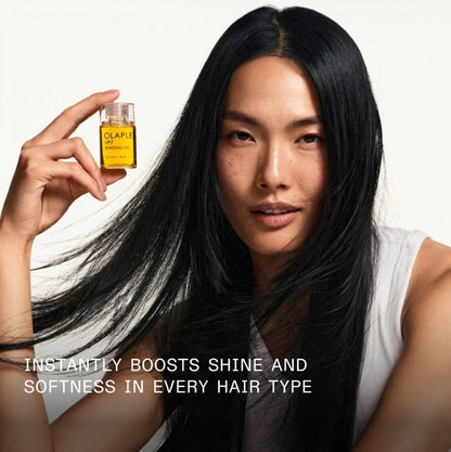 Woman holding a bottle of Olaplex hair oil with text about its benefit mentioned instantly boosts shine and softness in every hair type