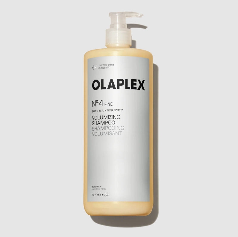 A bottle of Olaplex No.4 Fine Volumizing Shampoo with a white pump dispenser and a white label, best value size -1L- showing the pale yellow shampoo inside, set against a light gray background.