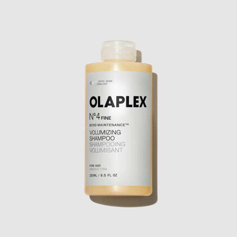 A bottle of Olaplex No.4 Fine Bond Maintenance Volumizing Shampoo, shown against a light gray background with a soft shadow.