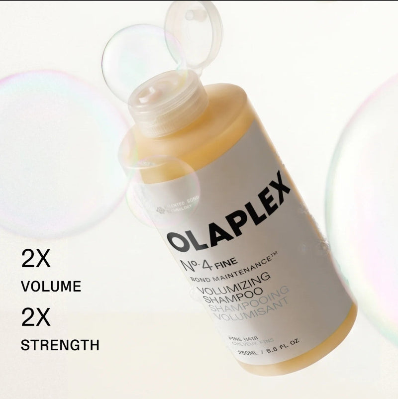 A bottle of Olaplex No. 4 Fine Bond Maintenance Volumizing Shampoo shown at an angle with a translucent cap open.