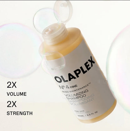 A bottle of Olaplex No. 4 Fine Bond Maintenance Volumizing Shampoo shown at an angle with a translucent cap open.