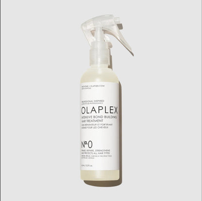 A bottle of Ola Plex Intense Bond Building Hair Treatment with a clear spray top and white label, shown on a light gray background.