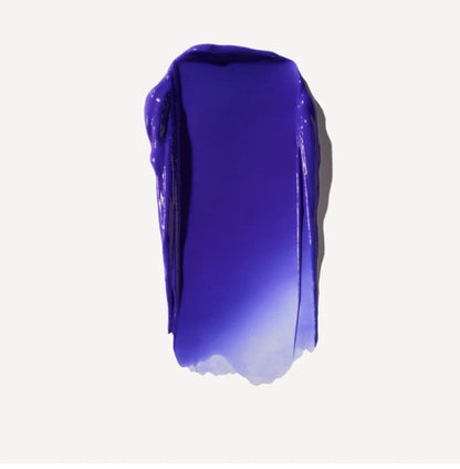 A thick, glossy swipe of deep purple Olaplex purple conditioner cream or gel on a clean, off-white background.