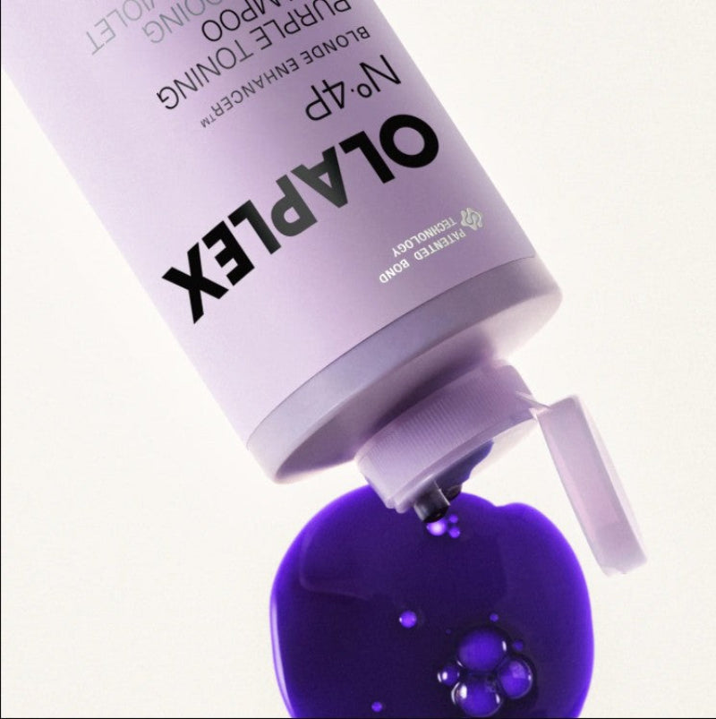 Olaplex No.4P Blonde Enhancing Purple Toning Amino product shown with its lavender bottle tilted to dispense a glossy deep purple liquid onto a clean white background.