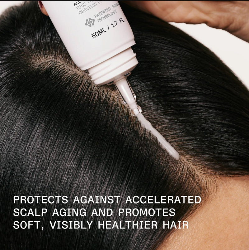 a model showing application of Olaplex scalp longevity treatment on her hair that protects her hair against accelerated scalp aging and promotes soft, visibly healthier hair