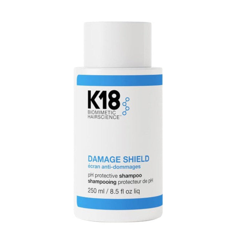 A white bottle of K18 Biometric Hairscience Damage Shield pH protective shampoo, 250 ml, on a solid white background.